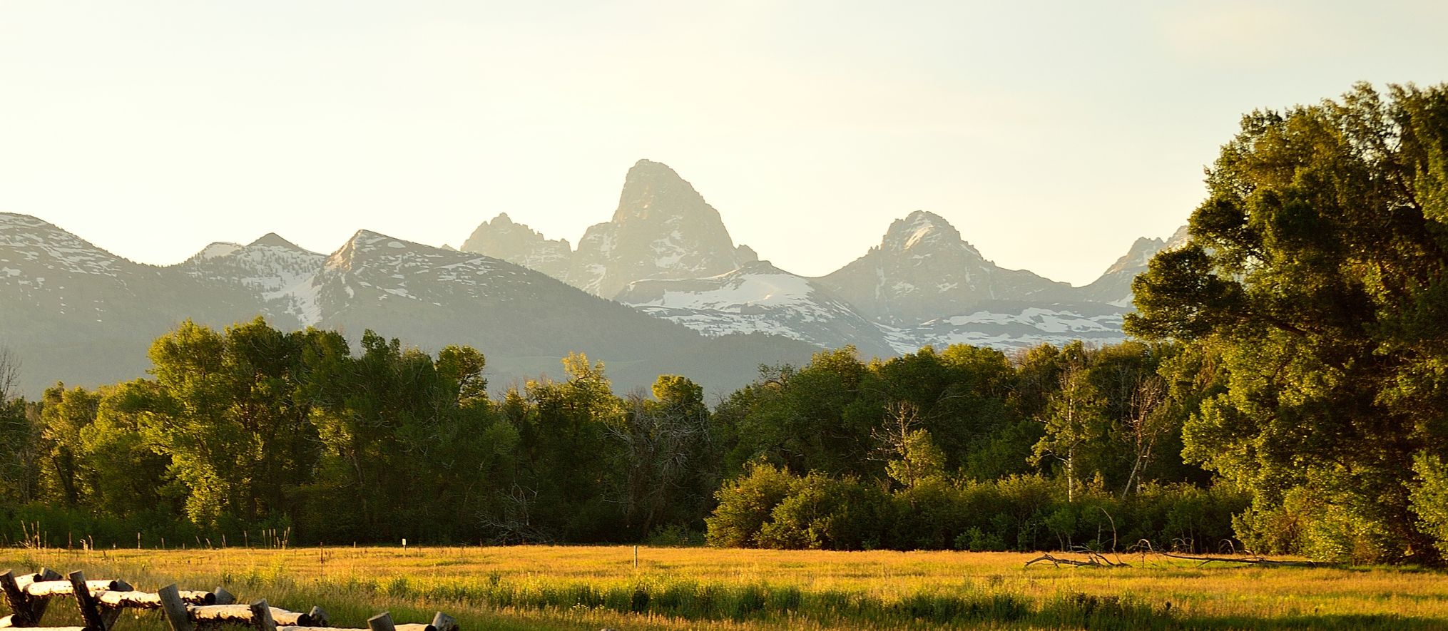Teton range at sunrise above open ranch land
